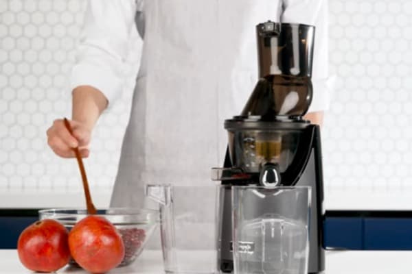pour pomegranate seeds in  juicer